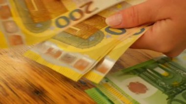 Avro faturaları. Para birikimleri ve tasarruflar. Kadınların elleri avro banknotlarını sayar. Avrupa 'daki kadınların harcamaları ve kazançları. 4k görüntü