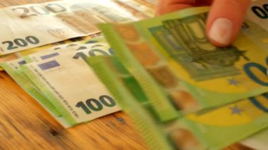 Para birikimleri ve tasarruflar. Avro banknotlarını kadınlar sayar. Avrupa 'daki kadınların harcamaları ve kazançları. 4k görüntü