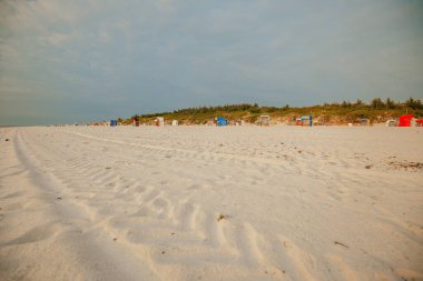  Kumlu plajlar ve beyaz kumsalda sahil kulübeleri. Deniz tatili. Deniz kıyısında tatil. Plaj havası. Kuzey Denizi 'nde tatil. Plaj yaz geçmişi