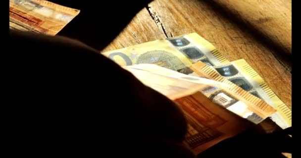 欧元银行在手 钞票算数 手中拿着欧元钞票 放在一张木制桌子上 点着一盏灯 4K镜头 — 图库视频影像