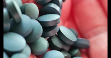 Yosun tabletleri hazır. Yeşil, kuru spirulina tabletleri. Doğal iyot kaynağı. Süper yemek. 4k görüntü
