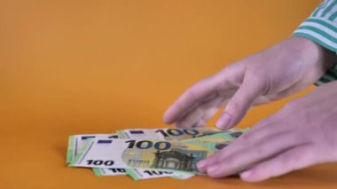 100 Euro 'luk banknotlar sarı bir sicile sahip. Para sayıyor. Para birimi sembolleri, Avrupa 'da maaşlar ve kazançlar. 4k görüntü