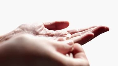 İlaçlar ve diyet takviyeleri. Beyaz kapsülleri beyaz bir arka planda diğer ele katlar. Yiyecek takviyeleri ve mineraller alır. 4k 'lik görüntü.