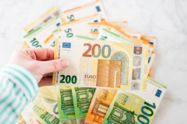 Elinde 200 Euro var. Mermer bir arka planda Avrupa banknotlarını yakından saymak. Para birimi notları ve sembolleri. 