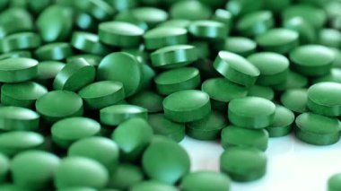 Yosun yeşili tabletler. Yavaş bir rotasyon. Sağlık ve uzun ömürlü olmak için Vitaminler ve besin takviyeleri. 4k görüntü