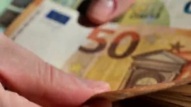 Avro parası. Yakın plan para yığını. Para sayıyorum. Avro banknotlarını parmaklayan parmaklar. 4k görüntü