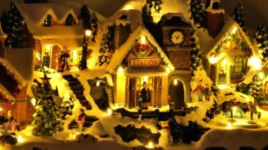 Kış kasabasında ışıklandırılmış insanların parlayan Noel kutuları. Hareketli dekorlu dekoratif Noel kutusu. Noel tatili dekoru. 4k görüntü