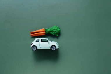 İnternette vejetaryen ürünler. Sebze ve meyve teslimatı. Yeşil bir arka planda çatıda havuçlu araba. Çevrimiçi alışveriş. - Evet. Market alışverişi ve teslimat
