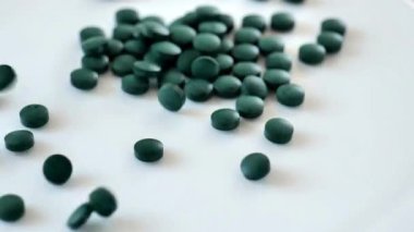 Kuru spirulina tabletleri: tablet şeklinde algler. Doğal iyot kaynağı. Süper yemek. Sağlıklı bir yaşam tarzı için gıda takviyeleri. Vitaminler ve diyet takviyeleri. 4k görüntü