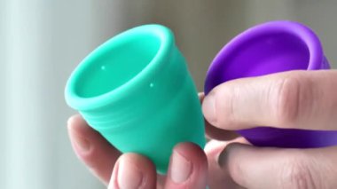 Kadınların adet dönemleri. Yeniden kullanılabilir silikon regl kupası. Yakın plan ellerde ilikonlu mestrual bardaklar. Sıfır genişlik, makul hijyen ve tüketim. Kadın sağlığı ve hijyen ürünleri. 4k görüntü