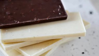 Mermer tabanlı beyaz ve siyah çikolata. Dairesel dönüş. Lezzetli iştah açıcı tatlı. 4k görüntü