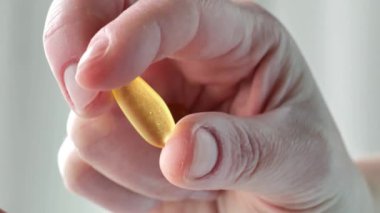 Kadın ellerinde balık yağı kapsülleri. Omega asit jelatin kapsülleri. Sağlıklı yağ ve kadınlar sağlıklıdır. Kadınlar için beslenme takviyeleri ve vitaminler. Kadın sağlığı için balık yağı. 4k görüntü