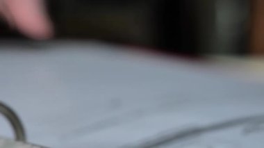 İçinde belgeler olan kırmızı dosya. Ev ve arsa planı. Elleri, içinde belgeler ve çizimler olan bir klasörü karıştırıyor. Mimari tasarımlar ve konut inşaatı için planlar. 4k görüntü