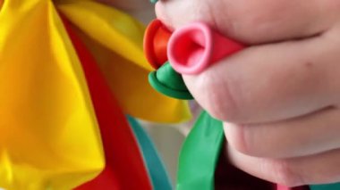 Ellerinde farklı renkte şişme toplar. Renkli lastik toplar. Doğum günü, bebek partisi ya da parti dekorasyonu. Şölen aletleri ve dekorasyonlar. 4k görüntü