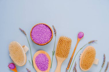 Lavanta işlemeli kozmetik seti. Mor arka planda lavanta tuzu ve doğal diş fırçaları ve lavanta çiçekleri.