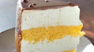 Kuş sütlü kek bölümü. Bir parça sufle keki yakın plan. Masadaki bir parça pastanın dokusu. Bölüm bölüm tatlı. 4k görüntü