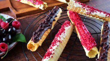 Kurutulmuş ahududu, şam fıstığı kırıntısı ve çikolatalı gözleme. Yenilebilir süslemeli çıtır gofret tüpü. Kıtır kıtır tatlı. 4k görüntü