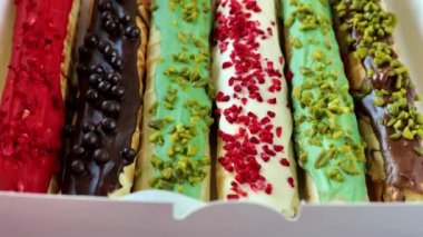 Çeşitli gofret ruloları. Kurutulmuş ahududu, şam fıstığı kırıntıları ve çikolatalı waffle ruloları. Yenilebilir süslemeli gevrek gofret tüpü. Çıtır çıtır tatlı.