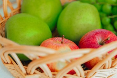  meyve sepeti. Üzümler ve yeşil elmalar sepetin içinde sabah güneşinde. Sağlıklı meyve atıştırmalığı. Lezzetli ve sağlıklı vejetaryen atıştırmalıkları. 