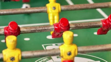 Futbolcuların figürleri yeşil masada hareket eder. Masa futbolu oynama süreci. Masa sporu. 4k görüntü