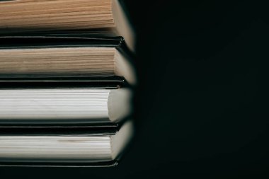 Kitap yığını. Siyah arka planda siyah kapaklı kitaplar. Kitap okuyorum. Okuma ve eğitim. Öğrenme ve bilgi sembolü.. 