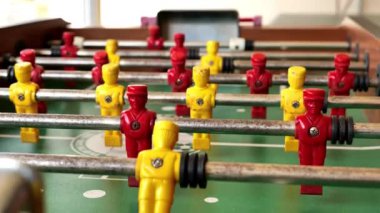 Masa futbolu. Masa oyunları. Sarı ve kırmızı futbolcular yeşil masada oynuyorlar. Ağır çekim. 4k görüntü