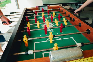 Masa sporu. Sarı ve kırmızı futbol oyuncuları yeşil bir masada oynuyorlar. Eğlence ve oyunlar