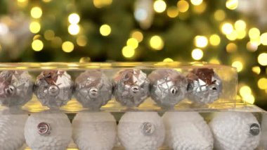 Noel alışverişi. Elleri saydam kutuların içinde parlak Bokeh çelenkleri diziyor.. 