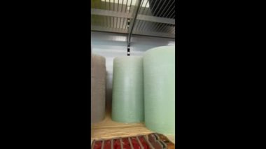 Parafin mumları bir mağaza rafına dizilmiş. Dikey video. Güzel ev dekoru. Çeşitli renklerde yuvarlak parafin mumlar. 4k görüntü