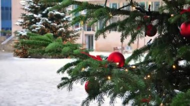 Almanya 'nın Nuremberg şehrinin karlı Noel sokaklarında kırmızı mücevherleri ve çelenkleri olan Noel ağaçları. 4k görüntü