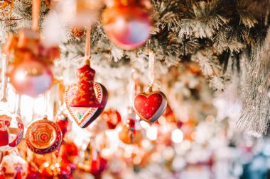 Noel pazarları. Çelenk ışığında parlak kırmızı tonları olan bir dekor. Noel alışverişi. Noel festivallerinde hediyeler ve dekorasyonlar almak.