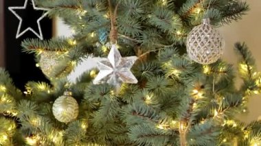 Parlak çelenkleri ve oyuncakları olan Noel ağacı. Gümüş tonlarda Noel ağacı süslemeleri. Gümüş ve mavi Noel süslemeleri olan mavi ladin. 4k görüntü