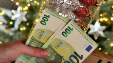 Noel ağacı süslemeleri. Eller cüzdandan para alır. 4k görüntü