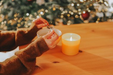 Fortune telling with melting tin.Winter Holiday Fortune Telling and Traditions.Fun tin casting set for New Years party.woman examines a piece of molten tin in her hands.New Years Traditions in Germany clipart