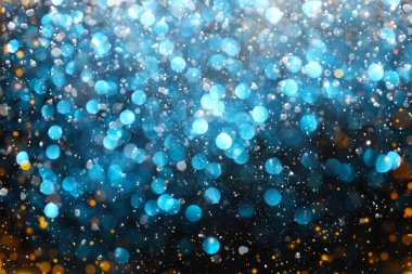 Duvar kağıtları parıldıyor. Mavi ve altın rengi parıltılı parıltılar. Yeni yıl ve Noel şenlikli arka plan. Siyah bir arka planda parlak bir bokeh ile ışıltılı makro fon. 