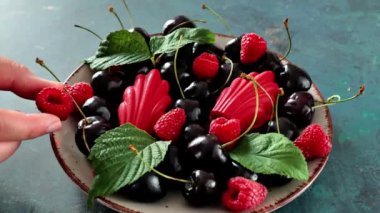 Vişneli ve ahududulu böğürtlenli meyveli kurabiyeler. Böğürtlenli pişirilmiş ürünler. Kırmızı kremalı Madeleine. Fransız kurabiyeleri. 4k görüntü