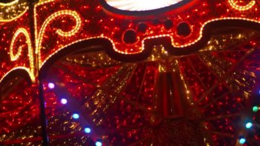 Atlıkarınca yakın çekim. Tatiller, panayır ve festival konsepti. Karanlıkta parlayan kırmızı atlı karınca. Noel tatilleri. Noel Işığı Kurulumları. 4k görüntü