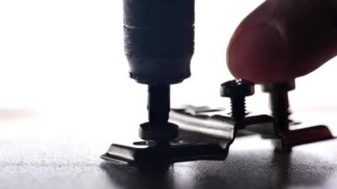Matkap, metal vidayı ahşap bir kalasa saplar. İnşaat ve marangozluk işi. Bir vida yakın çekim ekibi. Mobilya montajı. Bir vida ve matkap 45 'lik kamera görüntüsü.