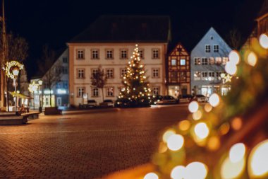 Gece şehir meydanında Noel Ağacı ve Işıkları. Gece şehir meydanında aydınlatılmış Noel Ağacı. Gece gökyüzünün altında bir Noel ağacı parlıyor..