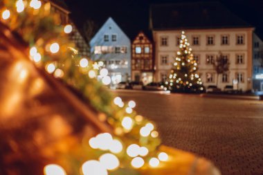 Gece şehir meydanında aydınlatılmış Noel ağacı. Şehir meydanında gece gökyüzünün altında bir Noel ağacı parlıyor..