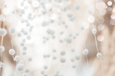 Pom-Pom Dekorasyonu. Bulanık yumuşak odak. Beyaz ve bej tonlarda sıklıkla arkaplan. Pastel gölgelerde havadar desen. Bokeh Arkaplan ile Beyaz Pom Poms.