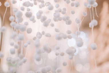 Yüzen elementlerle beyaz doku. Beyaz ponponlar Duvar Kağıdı. Hassas Pom-Pom Dekorasyonu. Beyaz ve bej tonlarda arka plan. Bokeh Arkaplan ile Soyut Beyaz Dekorasyon 