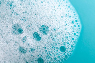 Köpüklü sabun köpüğü mavi bir arka planda. Temizlik ve hijyen köpüğü. Köpük temizleme ürünleri. Doku köpüğü yakın çekim. sabun köpükleri arka plan. 