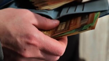 Para dolu cüzdan. Euro banknotlarının yakın plan çekimi. Avro banknotlarının el yığınları cüzdana sokuluyor. Zenginlik kavramı. 4k görüntü