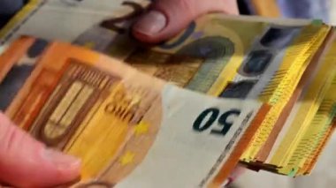 Büyük kazanç. Para saymak. Ellerinde bir tomar para var. Sağlam ikramiye. Avro banknotları dolu. Sosyal ödemeler ve sosyal yardımlar. Euro banknotları. 4k görüntü