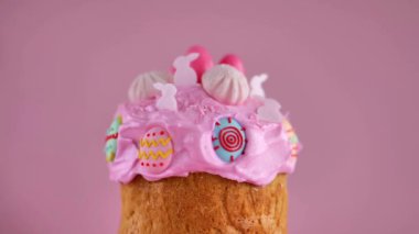 Paskalya pastası, pembe arka planda pastel pembe tonlarda şeker süslemeleri. 4k görüntü
