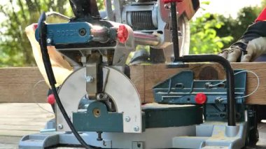 Tahtayı elektrikli testere ile kesme işlemi. BOSCH Multi Cutter. Heideck, Almanya. 21 Haziran 2023. İnşaat ve onarım çalışmaları. Ahşap işçiliği için ekipman