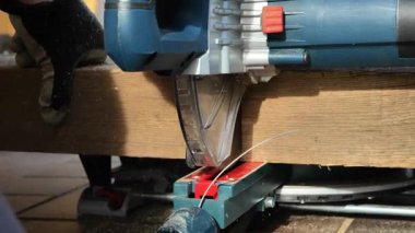  Marangozlar çalışır. Ahşap işçiliği için ekipman. Elektrikli testereyle tahtayı kesme işlemi.