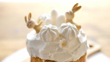 Beyaz paskalya pastası, kremalı, beyaz lokum ve tavşanlı. Pastaları eller süslüyor. 4k görüntü