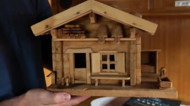 Ellerinde ahşap dağ evi modeli. İnşaat mimarisi modeli. Alp çadırı tarzında ahşap bir ev. Ahşap mimari. 4k görüntü